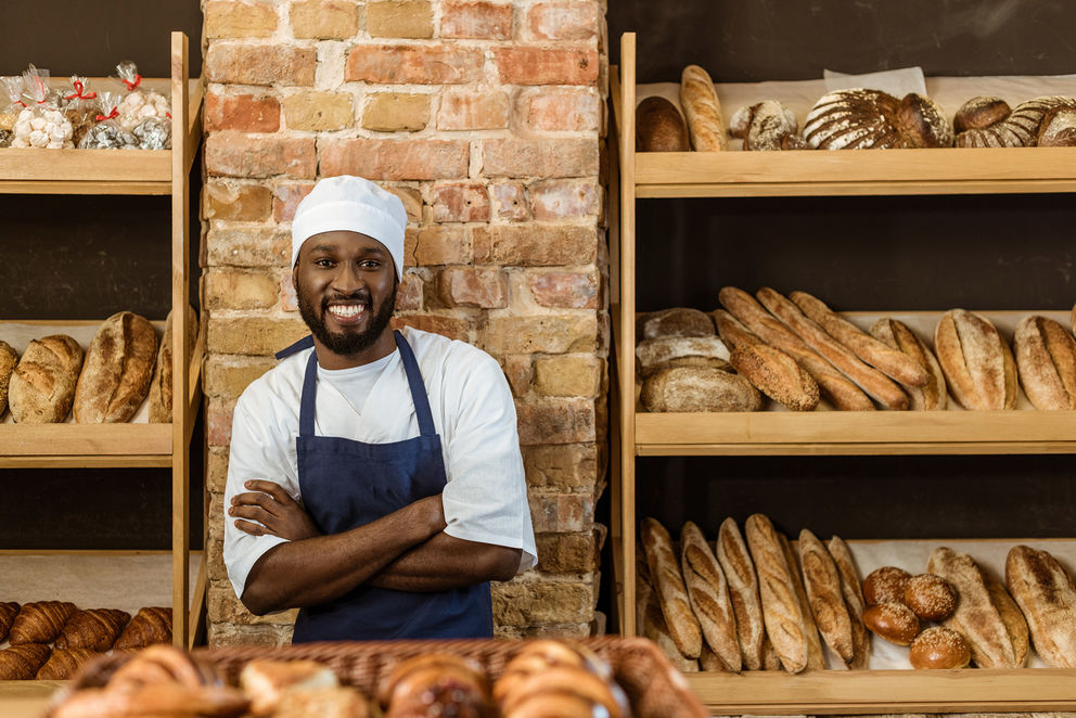 Smiling baker in front of freshly baked bread